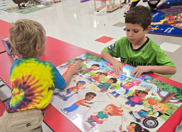 Two children sitting at a table engaged in a colorful puzzle activity.