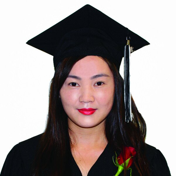 A portrait of a young woman wearing a black graduation cap and gown