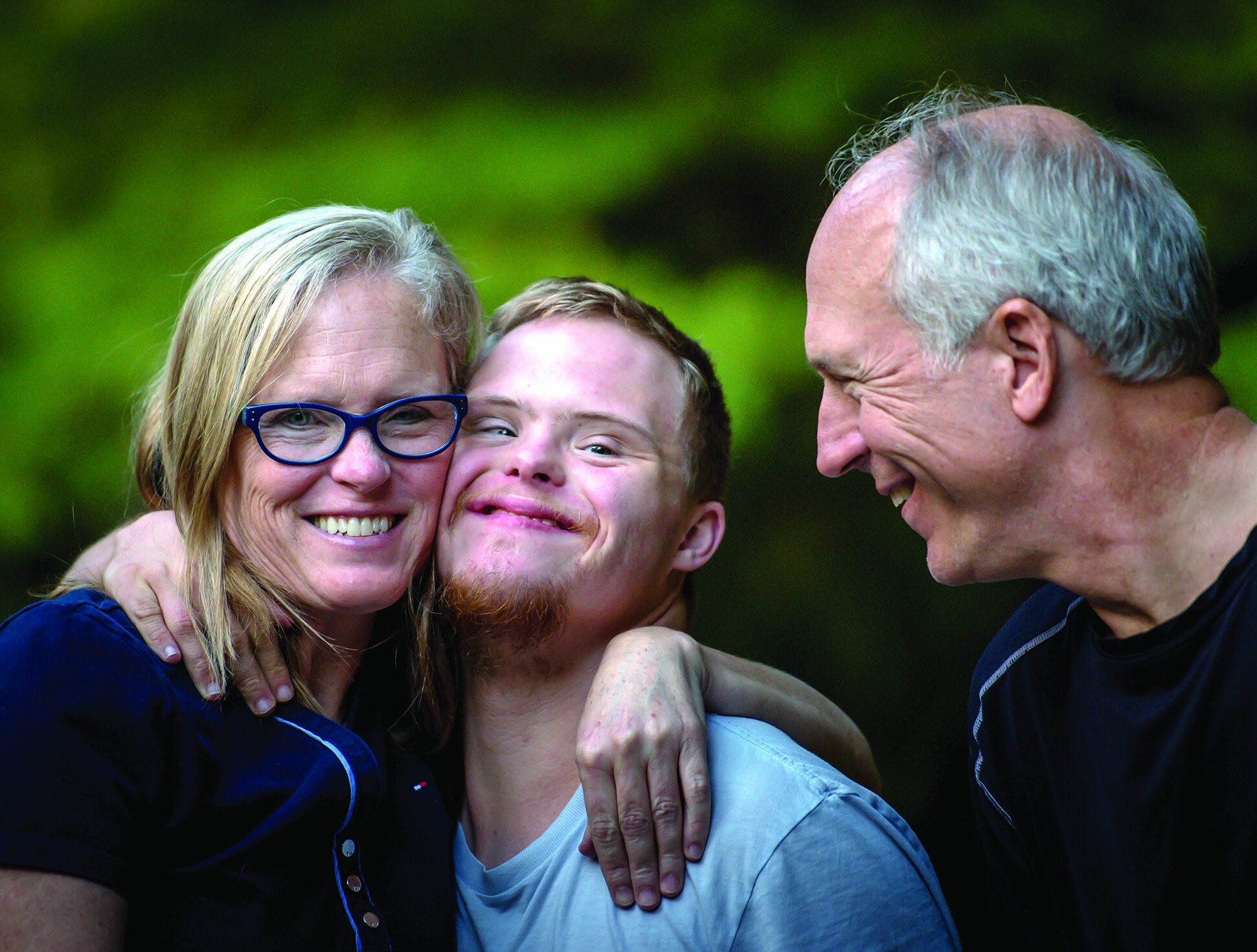 Three smiling adults sharing a joyful moment together
