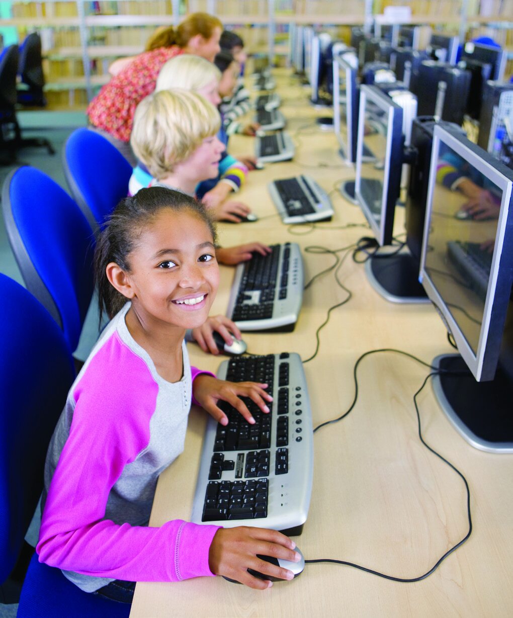 Student smiling while working in a computer lab