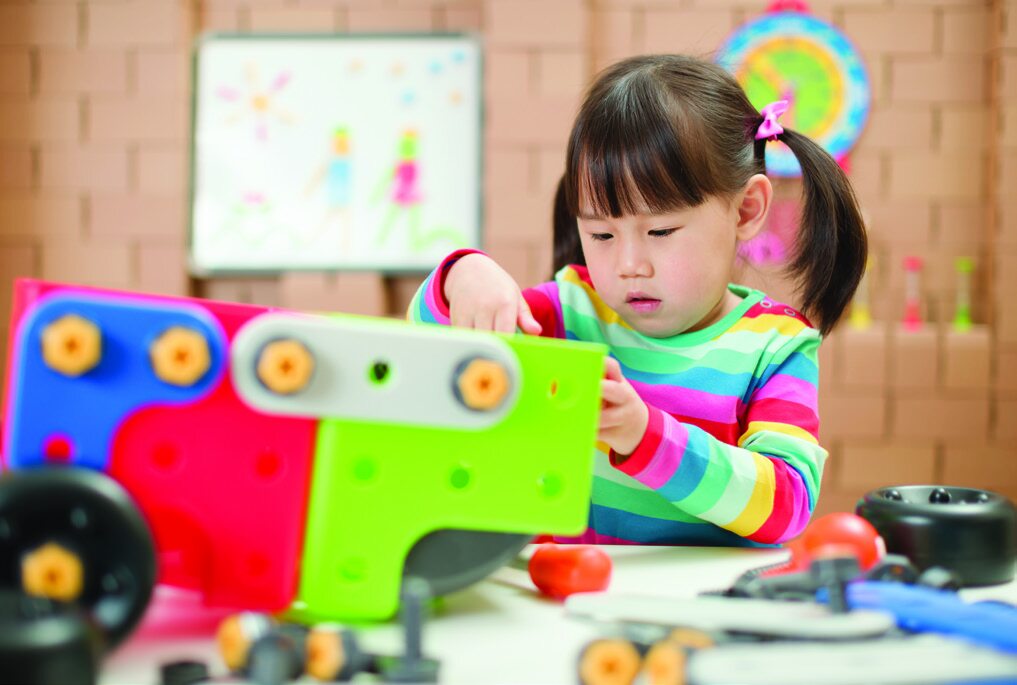 Child building a colorful mechanical structure