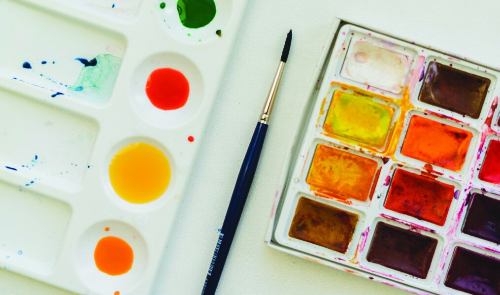 Art supplies including watercolor paints and brushes