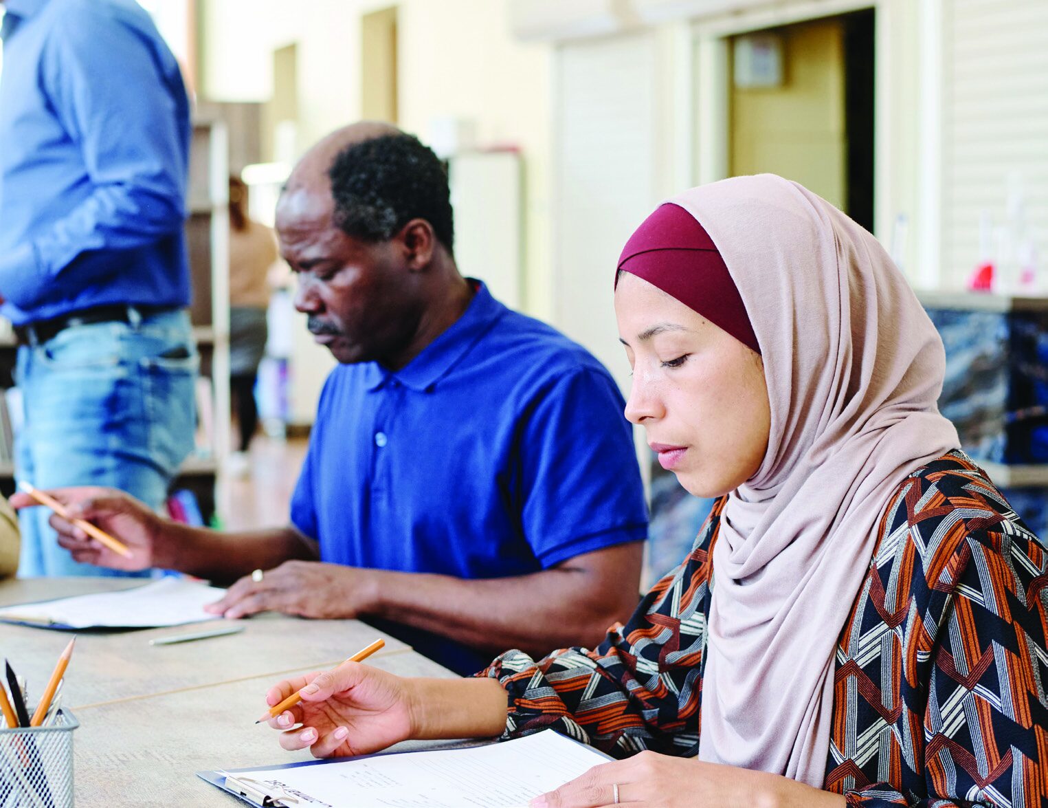 Diverse group of adult students studying together in a classroom at Harmony Learning Center.