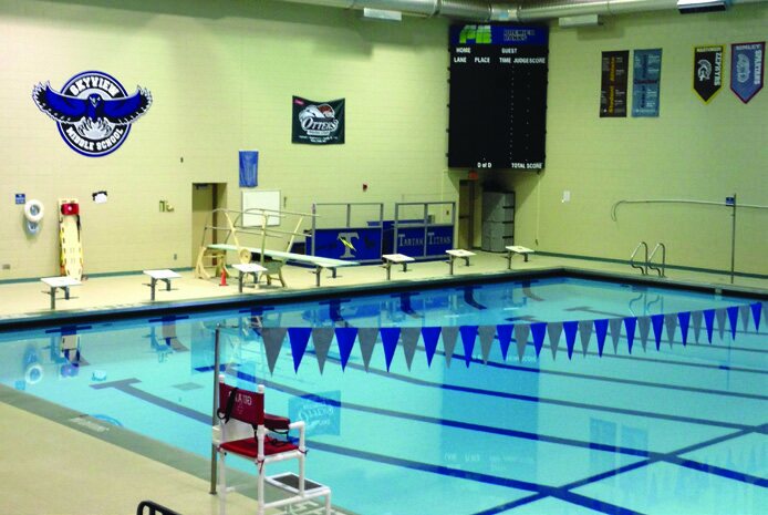 An indoor competitive swimming pool with lanes and starting blocks.