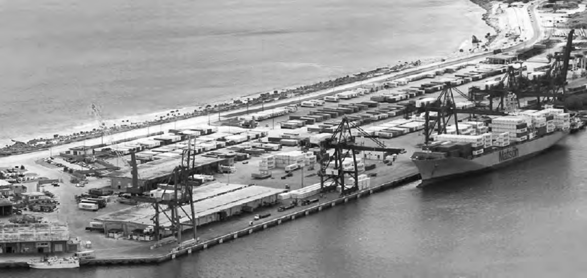 Aerial view of the Port of Guam showing container cranes, stacks of containers and a docked ship