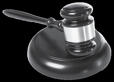 A wooden judge's gavel resting on a round sound block, photographed on a dark background