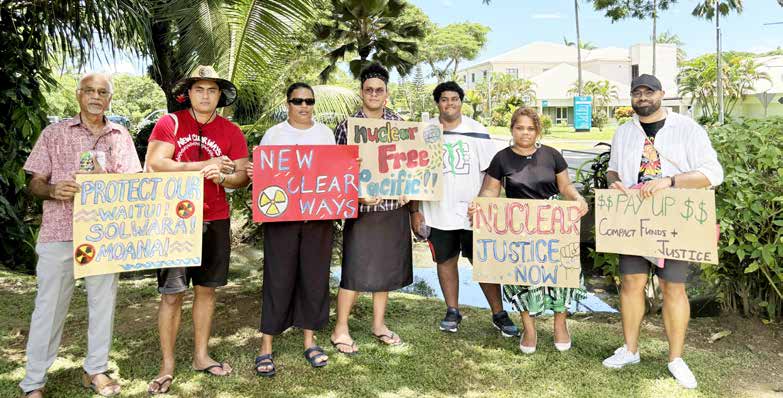 Group of protesters holding handmade signs in the Marshall Islands demanding justice