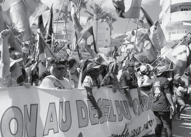 Protesters in New Caledonia holding banners and flags