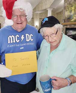Two people holding a card and a mug