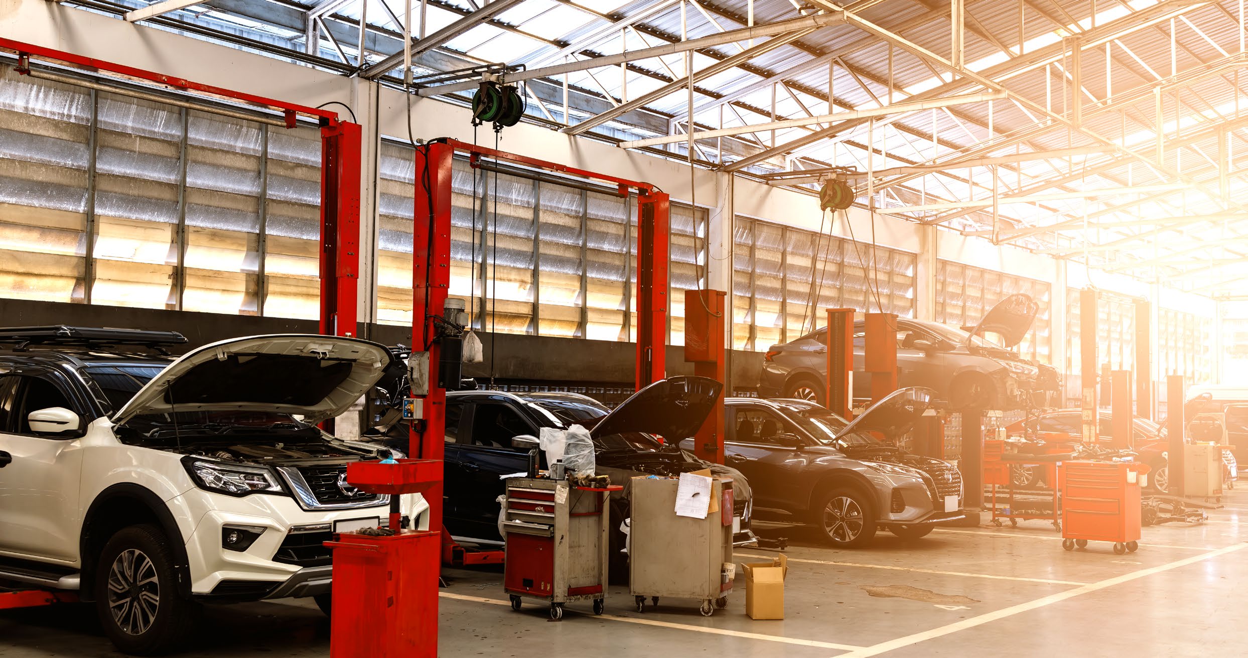 A modern automotive service workshop with vehicles on lifts