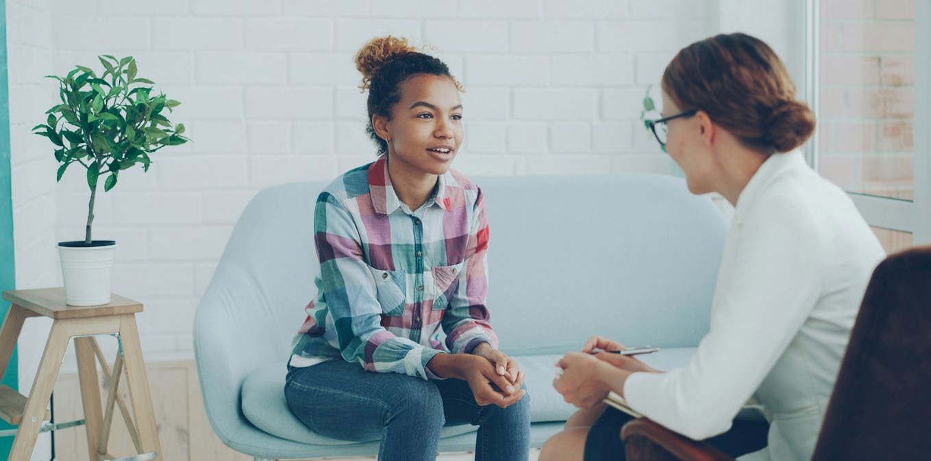 Two women engaged in a mentorship conversation in an office setting
