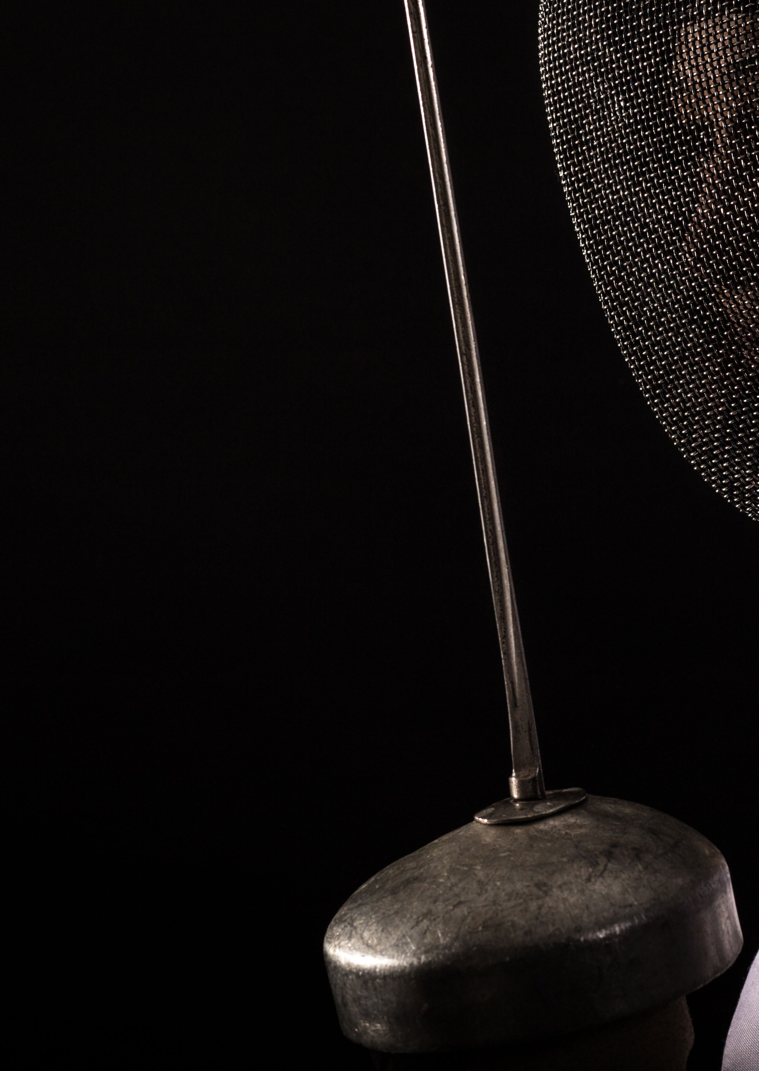A fencing mask and foil blade representing a shift in perspective.