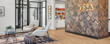 Interior lobby area at Vesa Apartments featuring modern seating and wood-textured walls