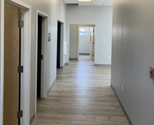 A renovated hallway featuring a wooden door and a modern light fixture.