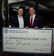 Andrew DeAngelo and Kenneth Reagan holding a ceremonial check for the Salvation Army Kroc Center