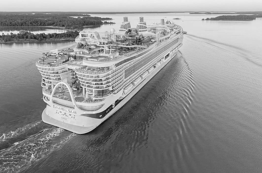 The massive Legend of the Seas cruise ship sailing through an archipelago.