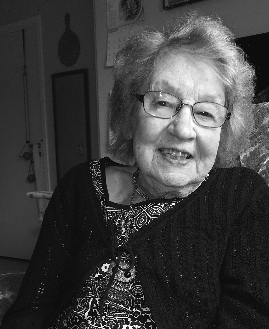 A black and white portrait of Hilja Nordner as an elderly woman, wearing glasses and a dark patterned cardigan.