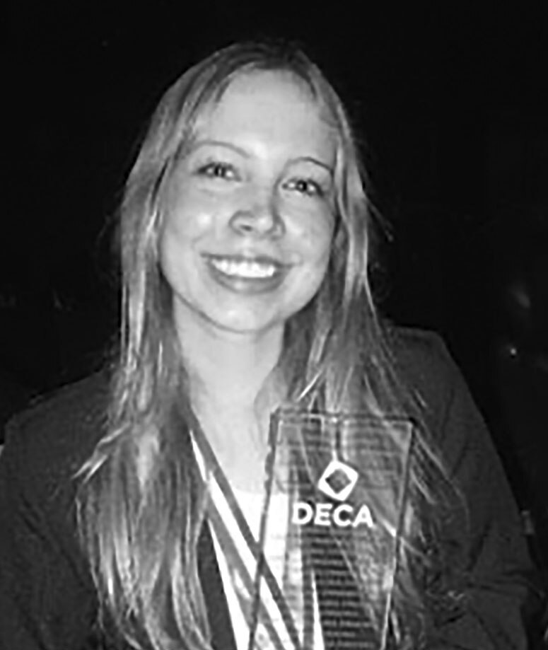 A black and white portrait of Miisa Peltola holding a DECA award