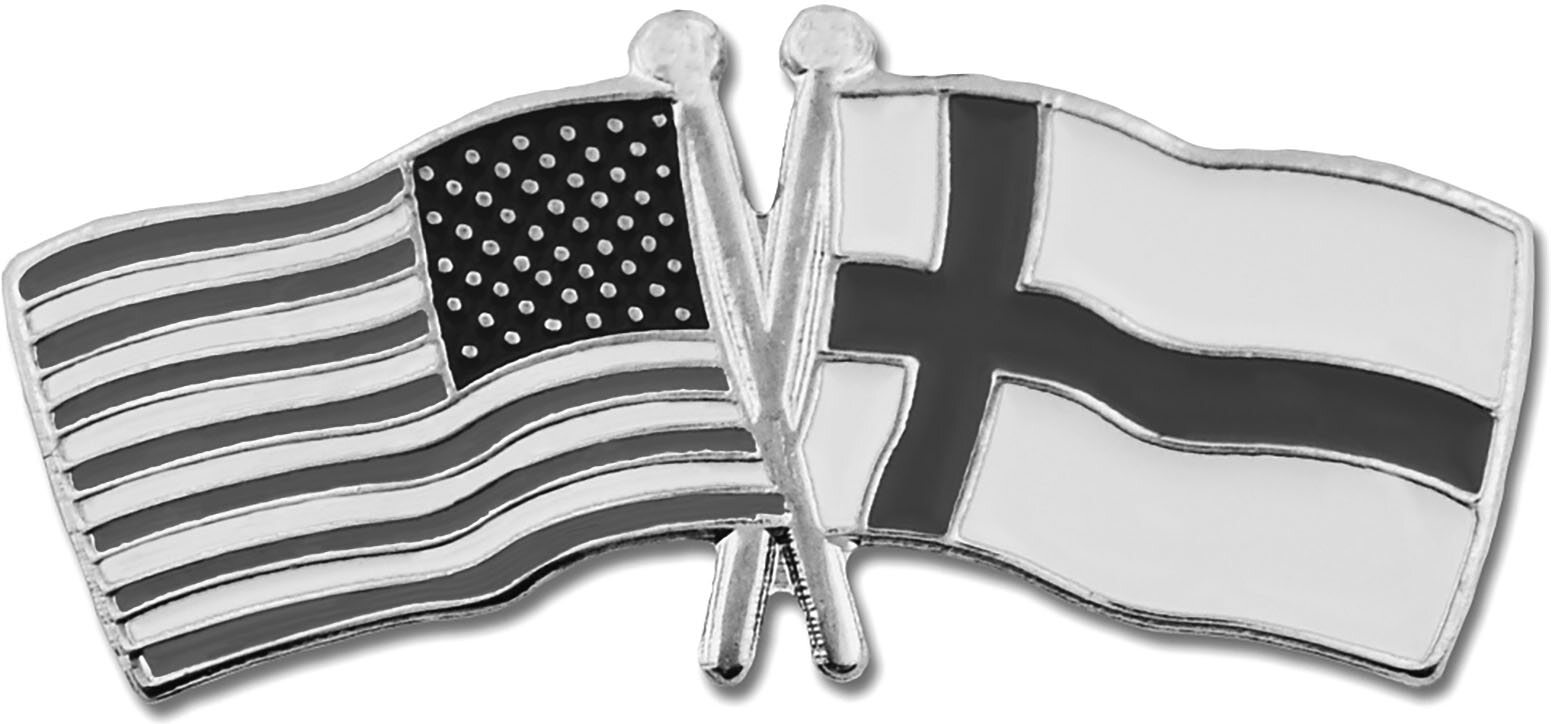 Two crossed lapel pins showing the United States flag and the Finland flag, photographed from above.