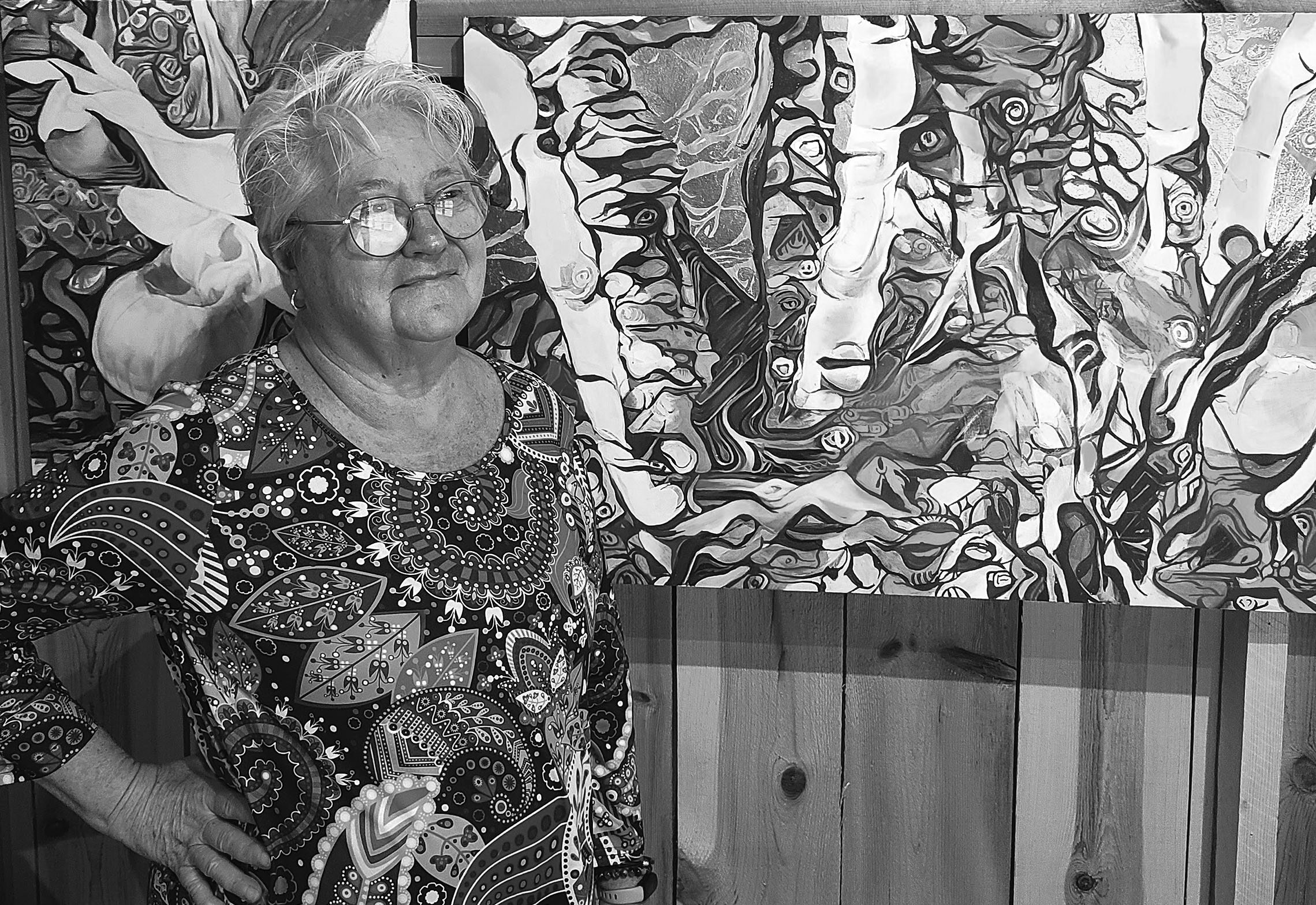 Mary Erickson in her studio beside a large painting that hangs on the wall.