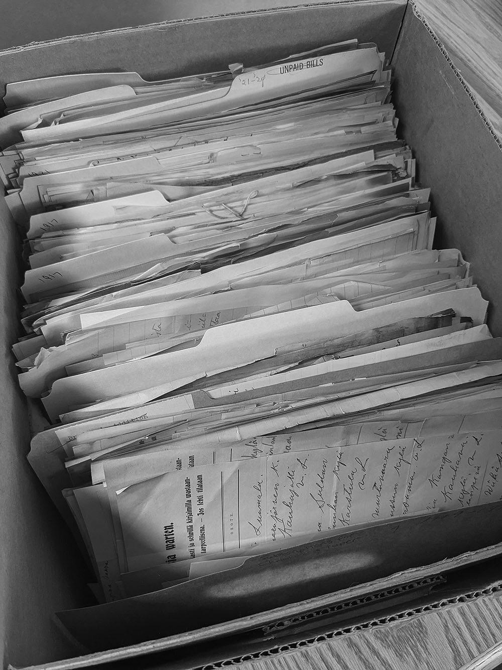 Archival box filled with folders and stacked papers prepared for digitization