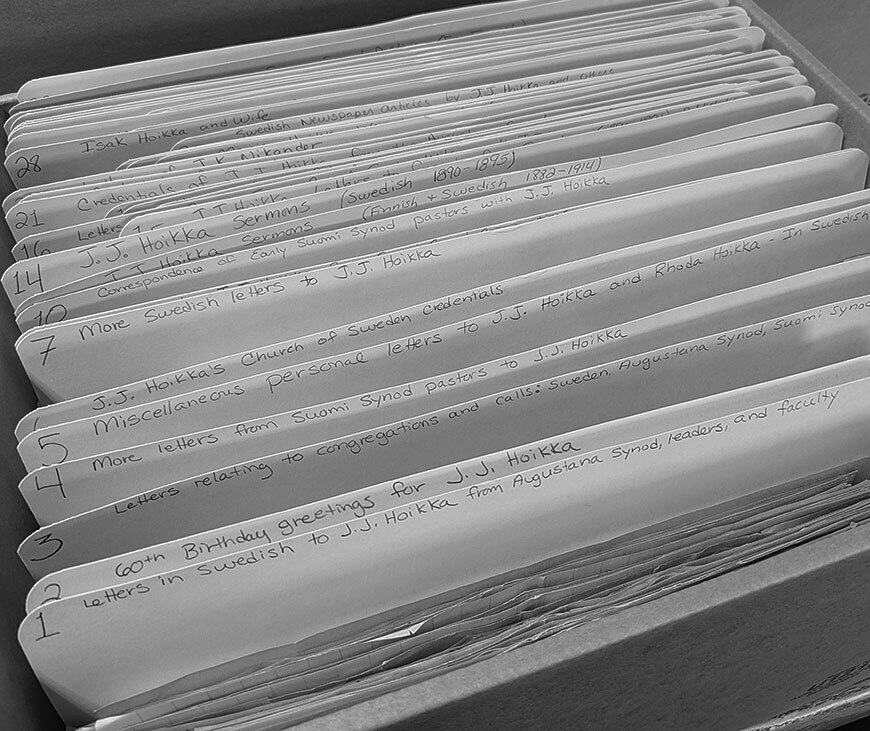 Close-up of a box of manila file folders with handwritten labels on the tabs