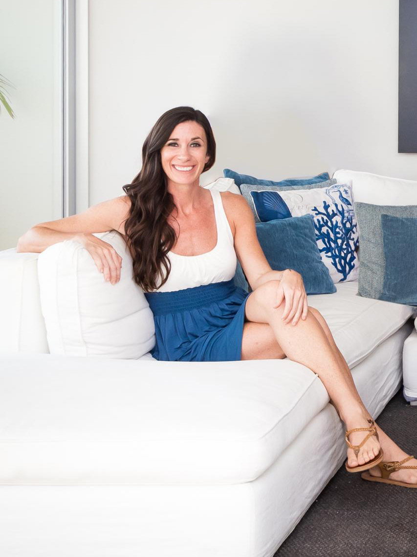 Portrait of Sarah Benz sitting on a white sofa