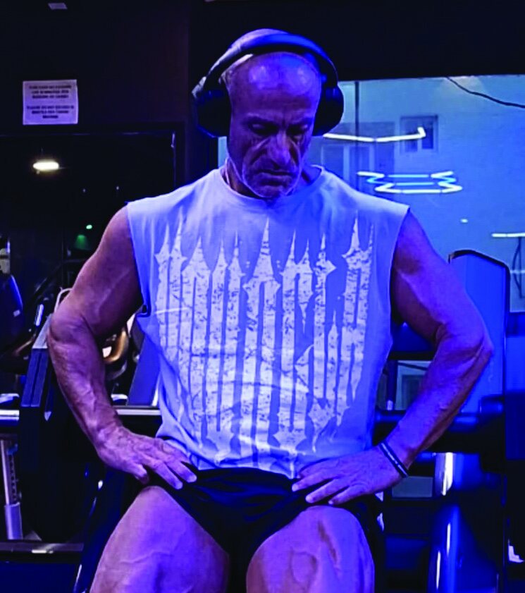 Leonard Torreblanca sentado en el gimnasio, con aud&iacute;fonos y camiseta sin mangas, manos en los muslos