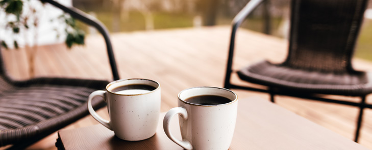 Two coffee mugs on an outdoor table