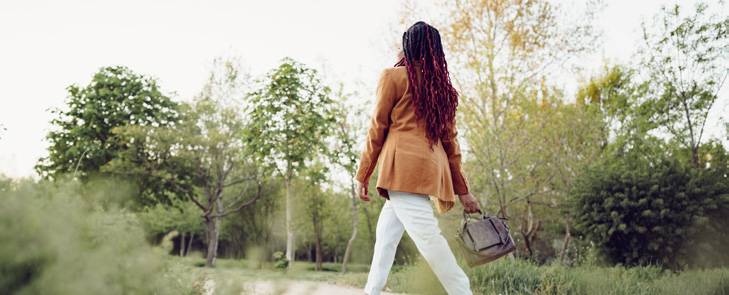 Person walking through a sunlit park
