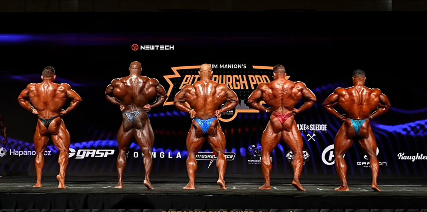 Five male bodybuilders in a back-pose lineup on the Pittsburgh Pro stage