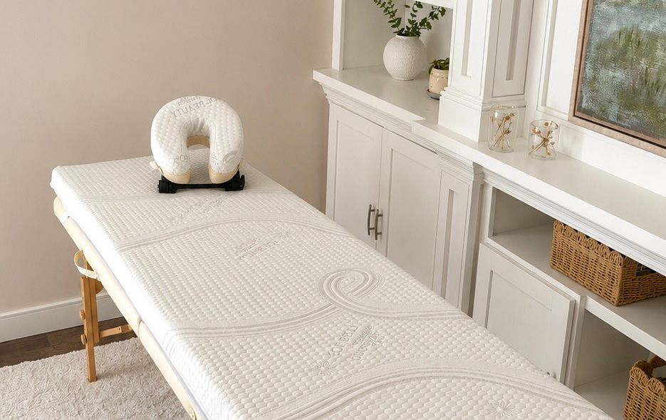 Spa treatment table with a white memory-foam topper and face cradle